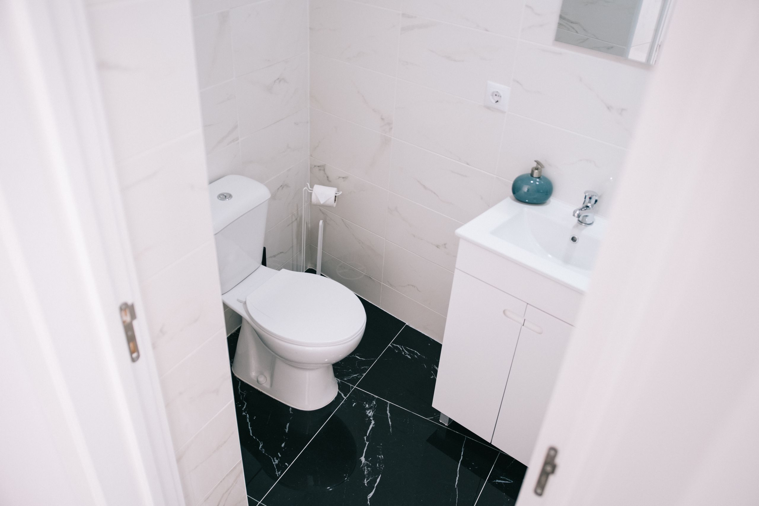 A contemporary bathroom showcasing a clean design with marble tiles and modern fixtures.